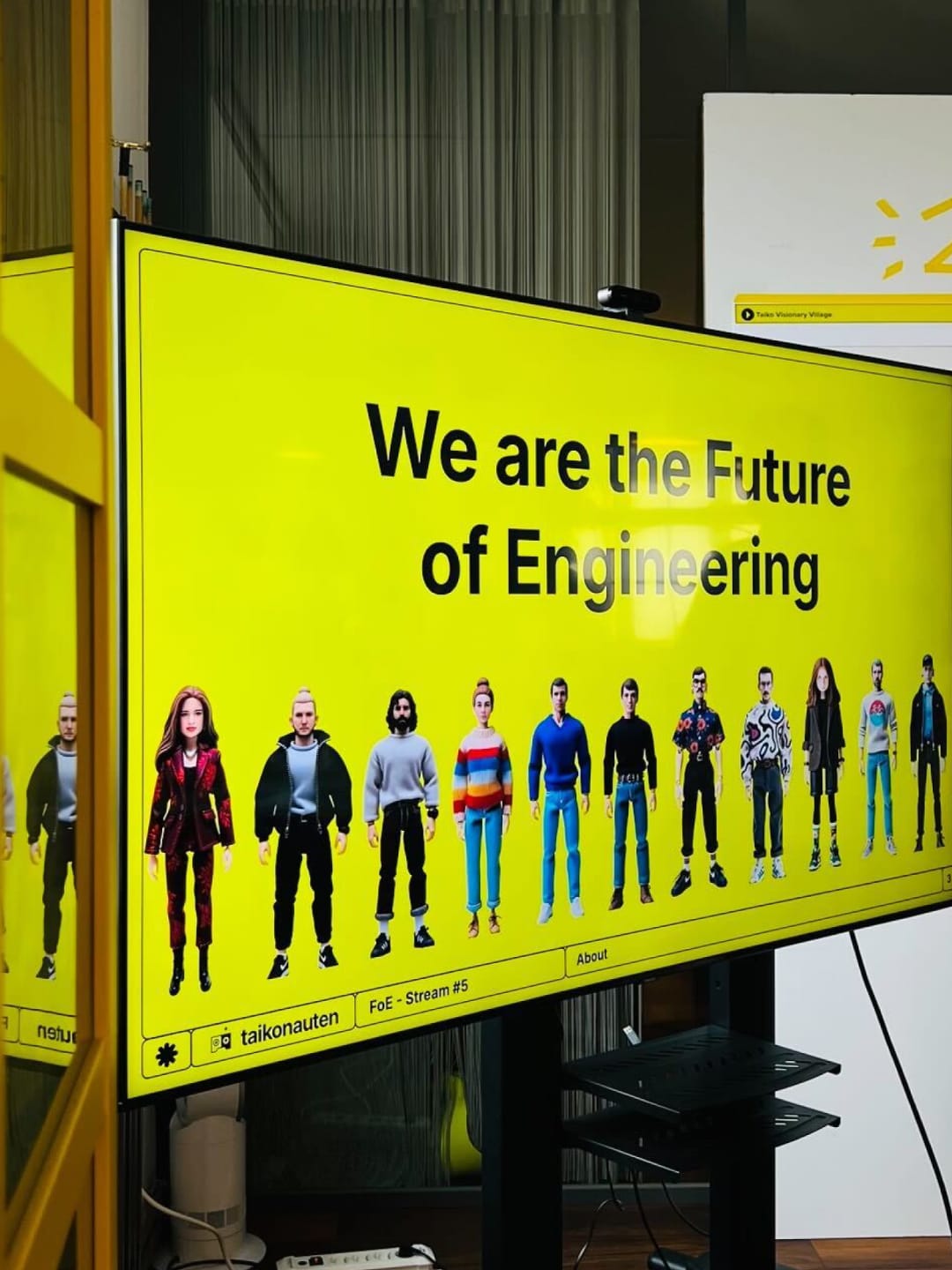 Ein großer Bildschirm zeigt eine gelbe Folie mit dem Titel "We are the Future of Engineering".