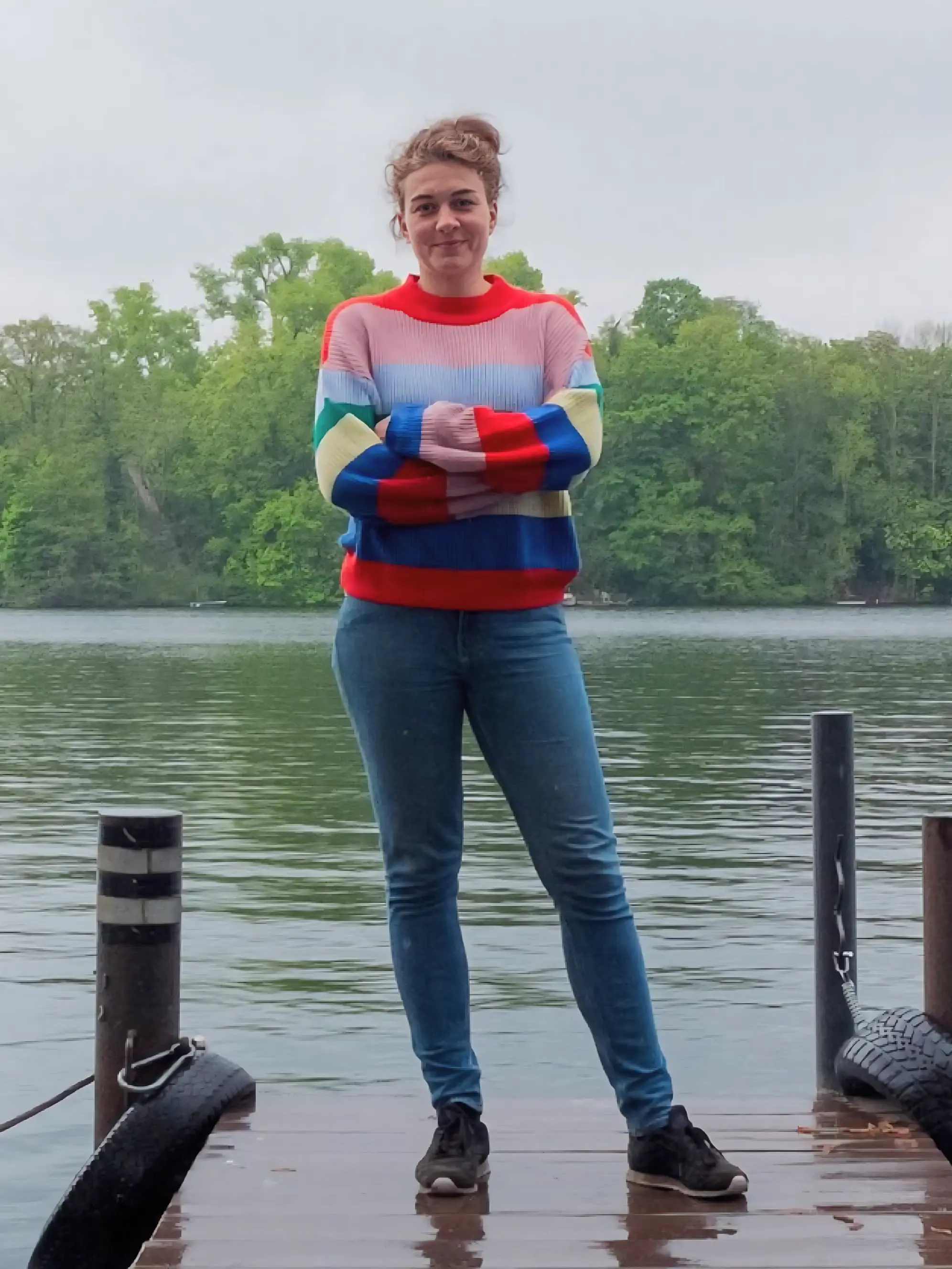 Frau mit buntem Oberteil an einem Bootsanleger