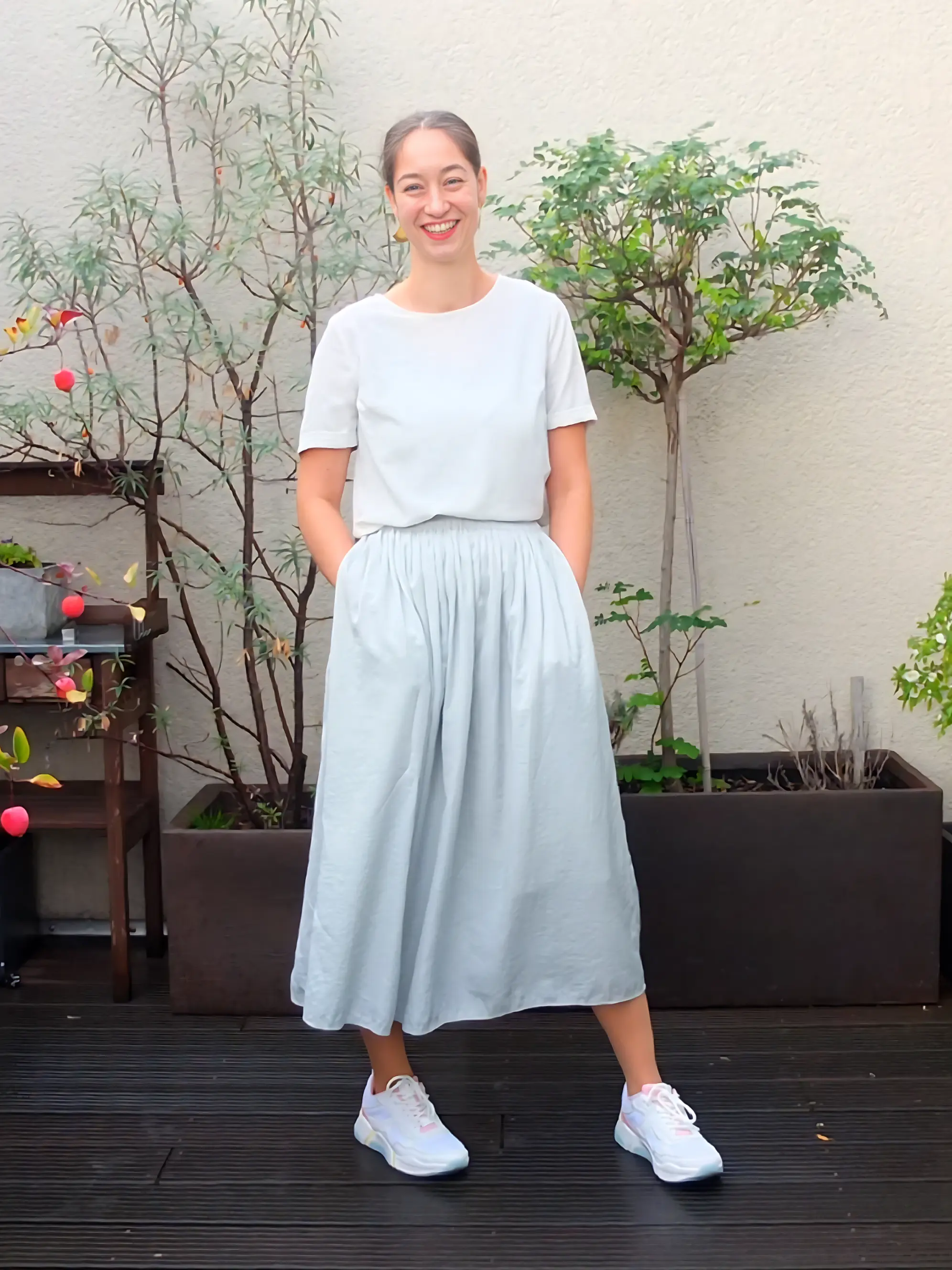 Junge Frau in weißem Kleid auf Dachterasse