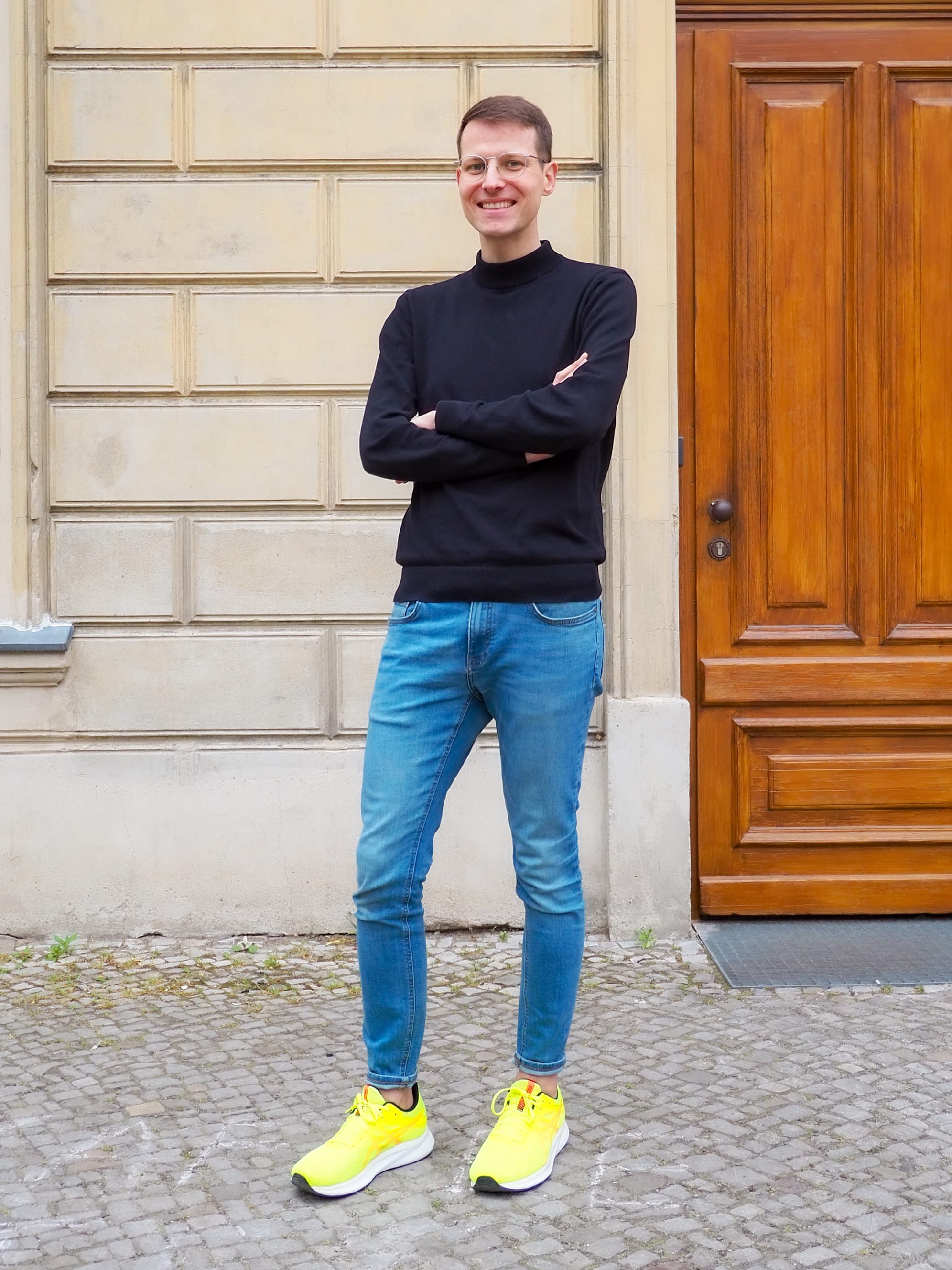 Ein Mann in weißem Hemd und schwarzer Hose hält eine rote Tasche.