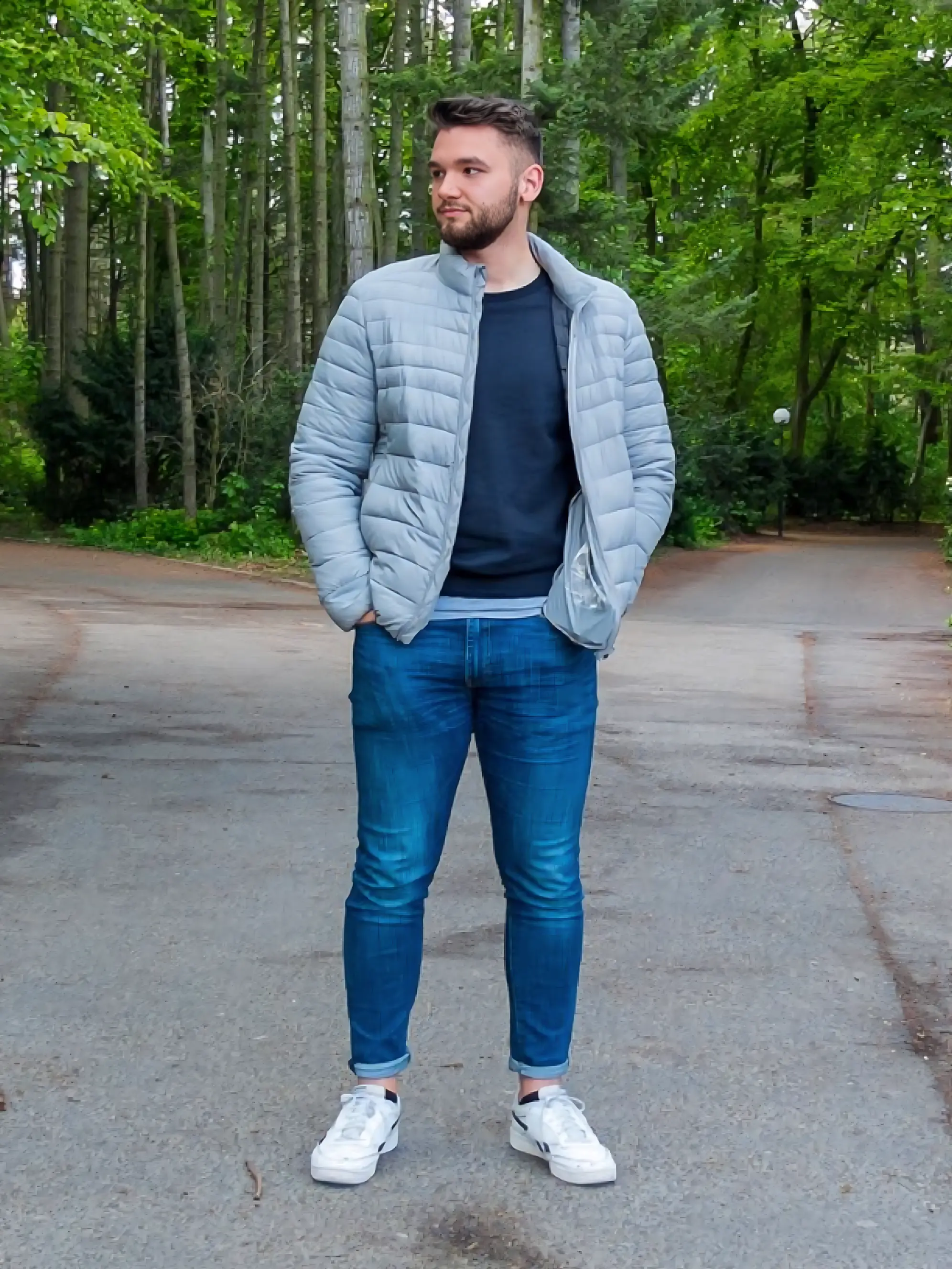 Mann mit grauer Steppjacke in Wald