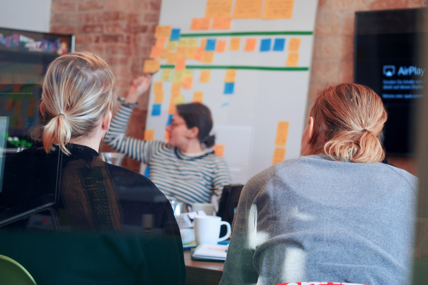 Frontalunterricht: zwei weibliche Personen von hinten, eine Frau an der Tafel. Frontalunterricht: zwei weibliche Personen von hinten, eine Frau an der Tafel.
